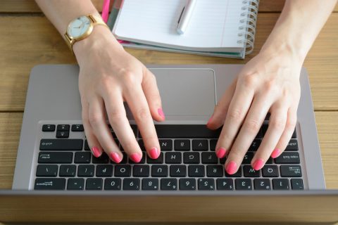 Woman typing on laptop computer